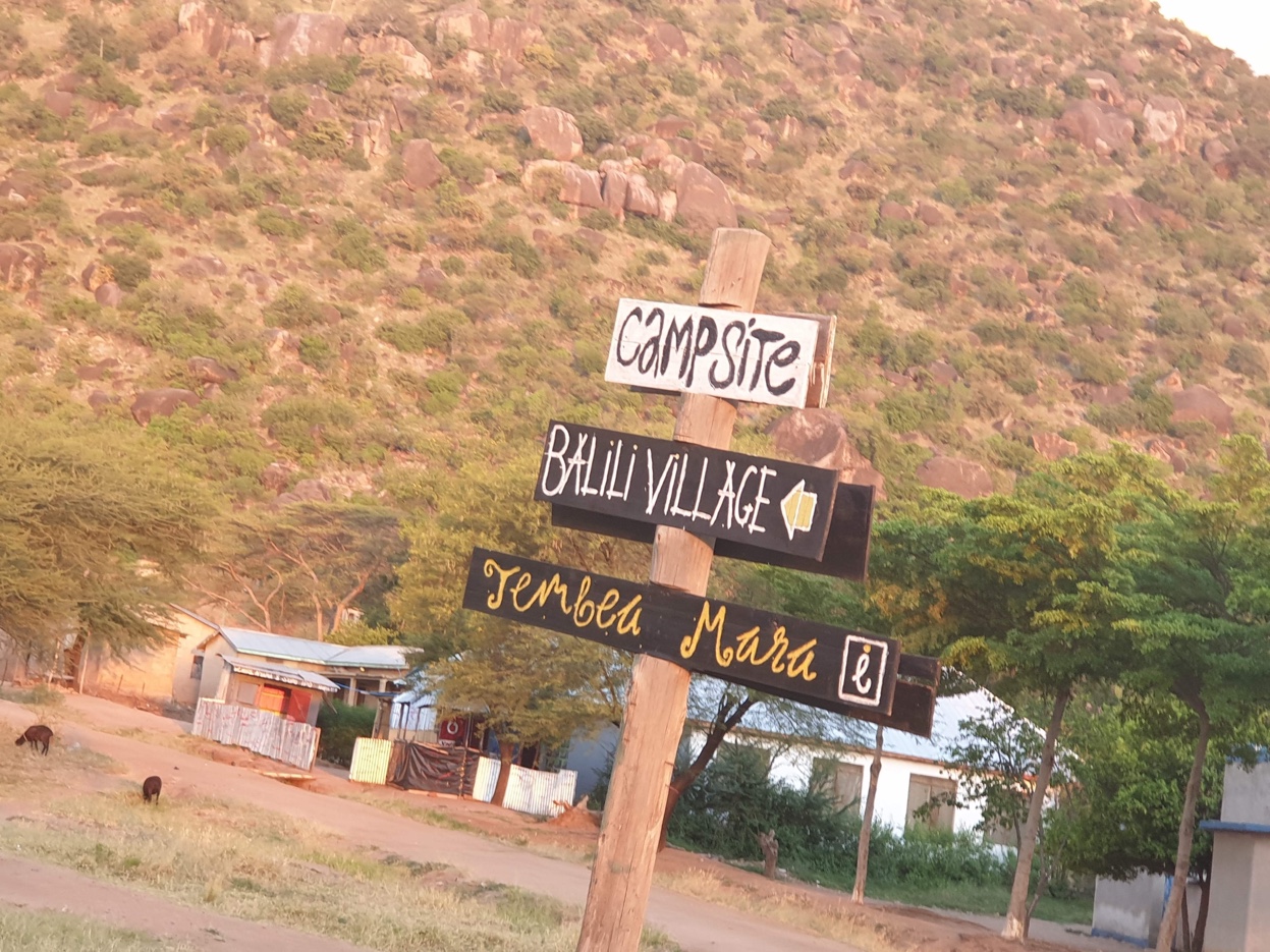 Directional signpost at Balili Village with the Balili Hills rising behind